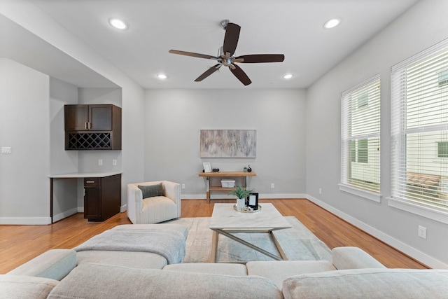 living room with recessed lighting, a ceiling fan, light wood finished floors, and a healthy amount of sunlight