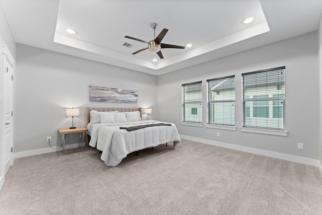 bedroom with recessed lighting, a raised ceiling, and carpet floors