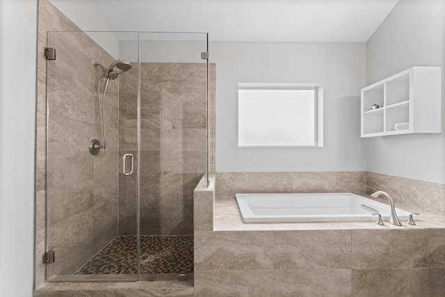 bathroom featuring a shower stall and a bath
