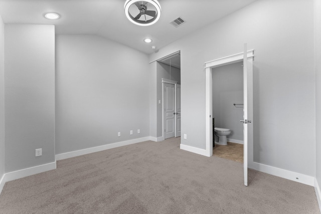 unfurnished bedroom with carpet floors, baseboards, lofted ceiling, and visible vents