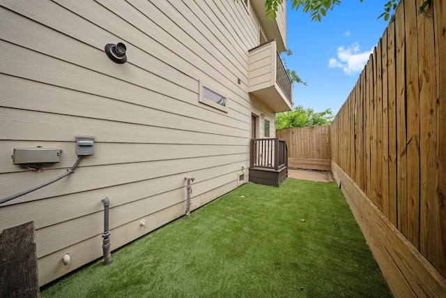 view of side of home with fence and a lawn