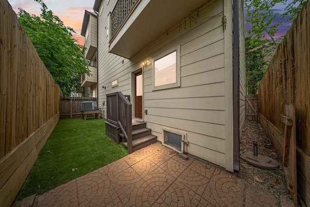 view of home's exterior with a yard, a patio, central AC, and a fenced backyard