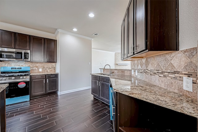 kitchen with light stone counters, ornamental molding, appliances with stainless steel finishes, and dark brown cabinets
