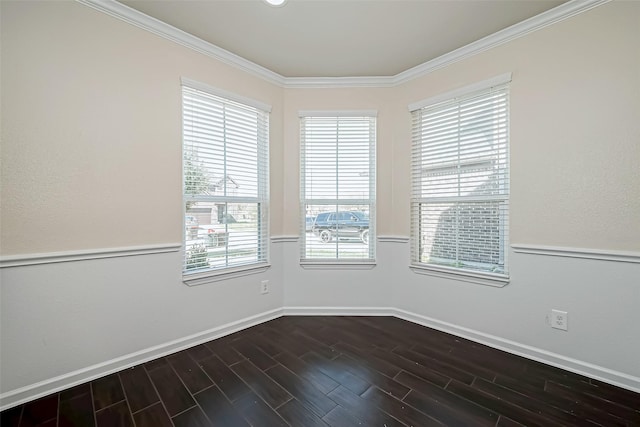 spare room featuring baseboards, ornamental molding, and dark wood finished floors