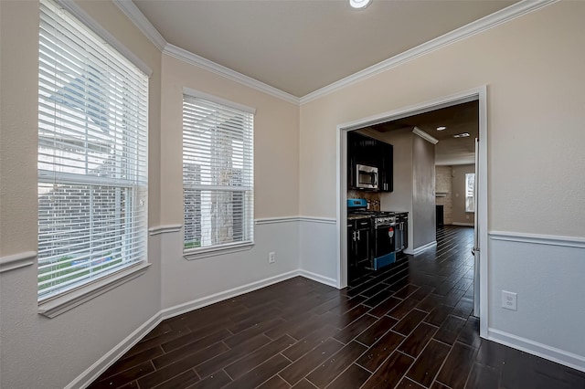 interior space with baseboards, ornamental molding, stainless steel appliances, and dark wood finished floors
