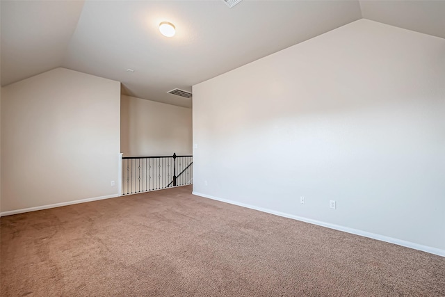 additional living space with baseboards, carpet, vaulted ceiling, and visible vents