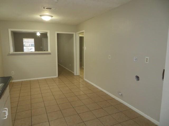 unfurnished room with light tile patterned floors, baseboards, and visible vents