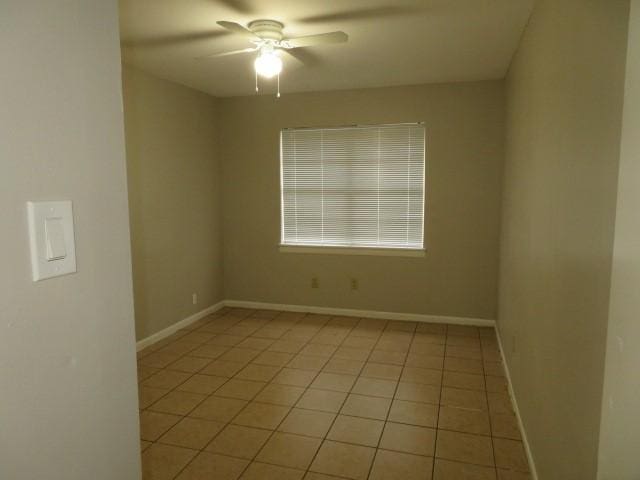 spare room with a ceiling fan, baseboards, and light tile patterned floors