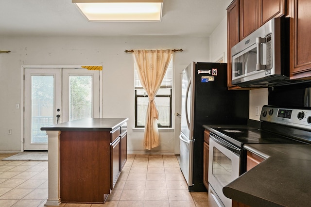 6310 Ringsby Rd, Austin, TX 78747 - kitchen with a kitchen island, stainless steel appliances, dark countertops, and light tile patterned flooring