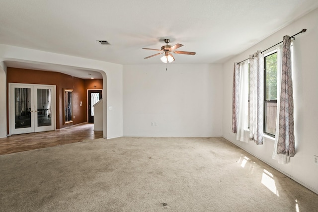 6310 Ringsby Rd, Austin, TX 78747 - carpeted empty room featuring visible vents, arched walkways, a ceiling fan, and french doors