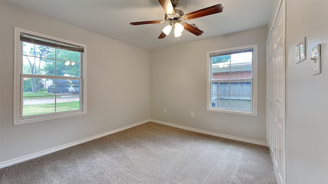 unfurnished room featuring carpet, baseboards, and a ceiling fan