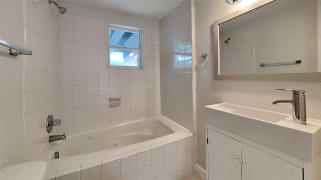 full bathroom featuring toilet, tiled shower / bath, and vanity