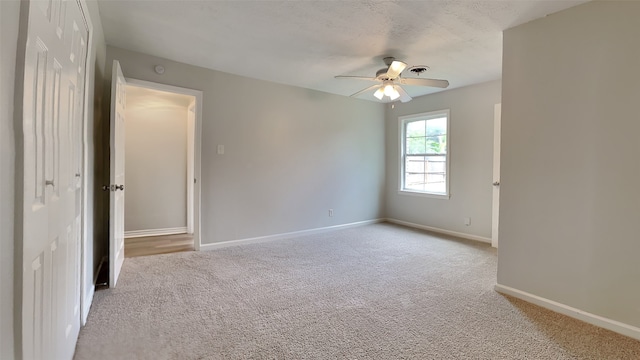 empty room featuring a ceiling fan, baseboards, and carpet floors