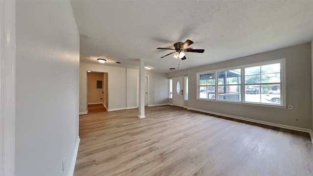 unfurnished living room featuring light wood-style floors, ceiling fan, baseboards, and a textured ceiling