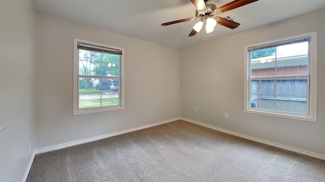 carpeted spare room with healthy amount of natural light, baseboards, and a ceiling fan