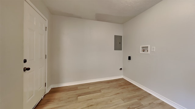 laundry area with washer hookup, light wood-style flooring, baseboards, electric panel, and a textured ceiling