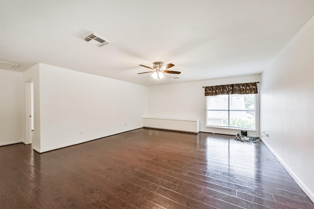 unfurnished room with a ceiling fan, baseboards, visible vents, and dark wood finished floors