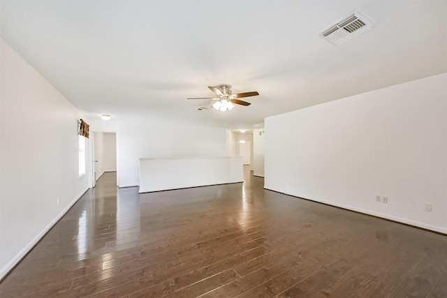 unfurnished living room featuring ceiling fan, visible vents, dark wood-style floors, and baseboards