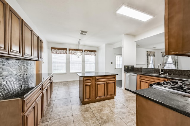 kitchen with stainless steel dishwasher, visible vents, a chandelier, a sink, and backsplash