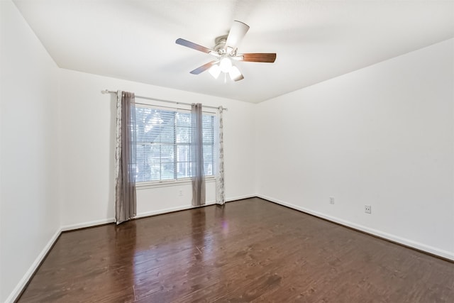 empty room with ceiling fan, dark wood-style floors, and baseboards