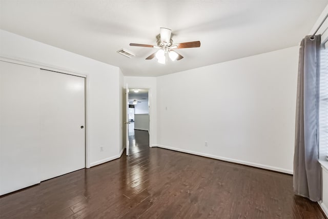 unfurnished bedroom with ceiling fan, visible vents, wood finished floors, baseboards, and a closet
