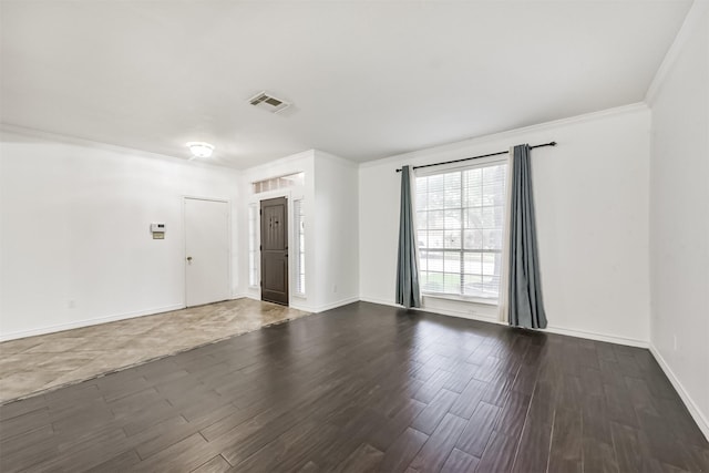 spare room featuring visible vents, dark wood finished floors, crown molding, and baseboards