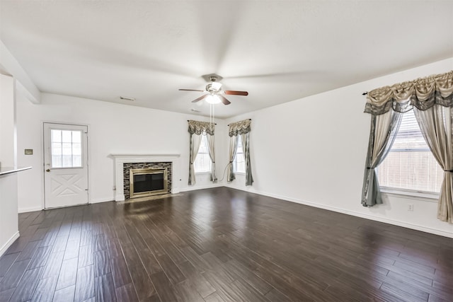 unfurnished living room with dark wood-style flooring, a ceiling fan, baseboards, a fireplace with flush hearth, and visible vents