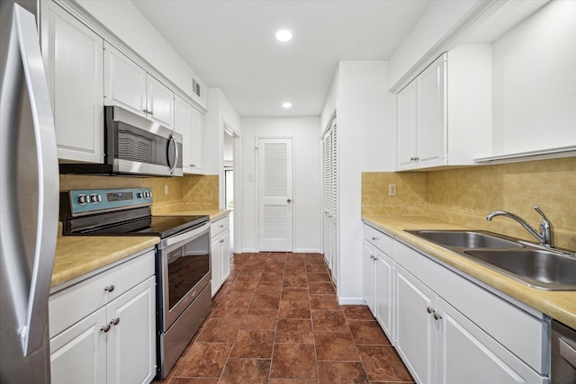 5827 Valley Forge Dr Unit 83, Houston, TX 77057 - kitchen featuring appliances with stainless steel finishes, a sink, backsplash, recessed lighting, and white cabinets