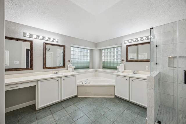 bathroom with a sink, a textured ceiling, two vanities, and a shower stall