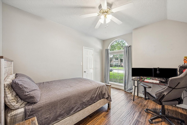 bedroom featuring ceiling fan, a textured ceiling, lofted ceiling, and wood finished floors
