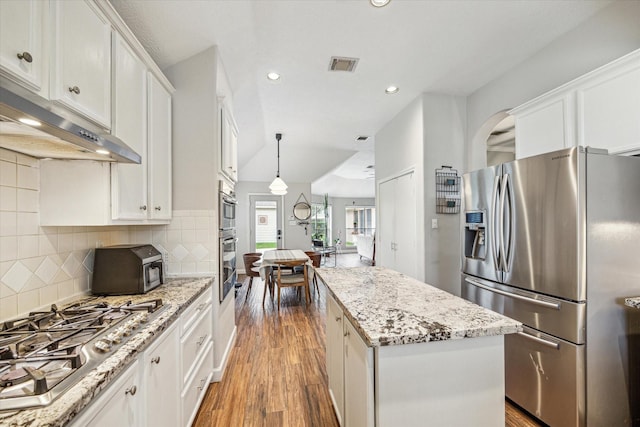 kitchen with recessed lighting, under cabinet range hood, a center island, visible vents, and stainless steel appliances
