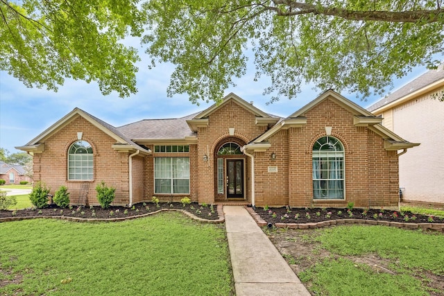 single story home featuring brick siding and a front lawn