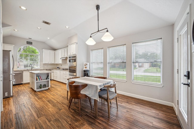 dining space featuring vaulted ceiling, baseboards, visible vents, and wood finished floors