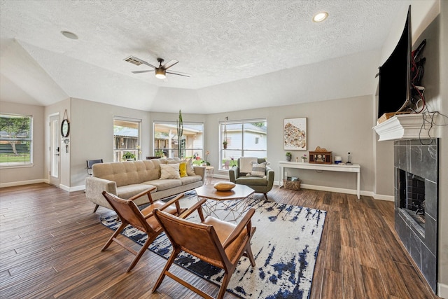living area featuring baseboards, ceiling fan, and a textured ceiling