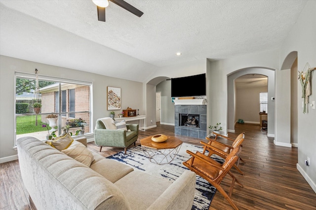 living area with ceiling fan, arched walkways, baseboards, and wood finished floors