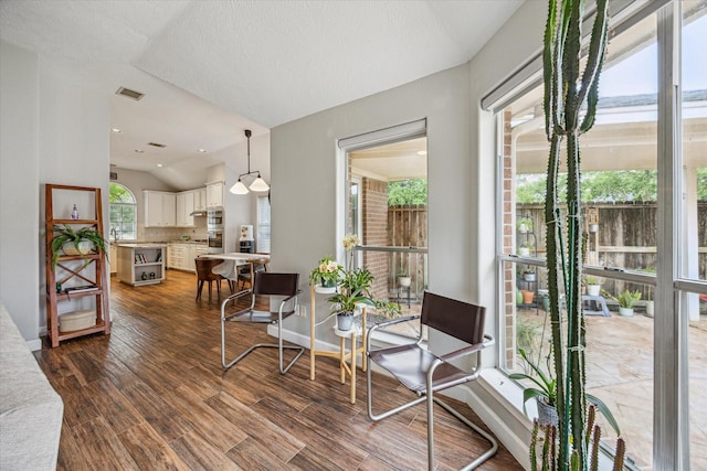 dining room with baseboards, dark wood-style flooring, visible vents, and vaulted ceiling