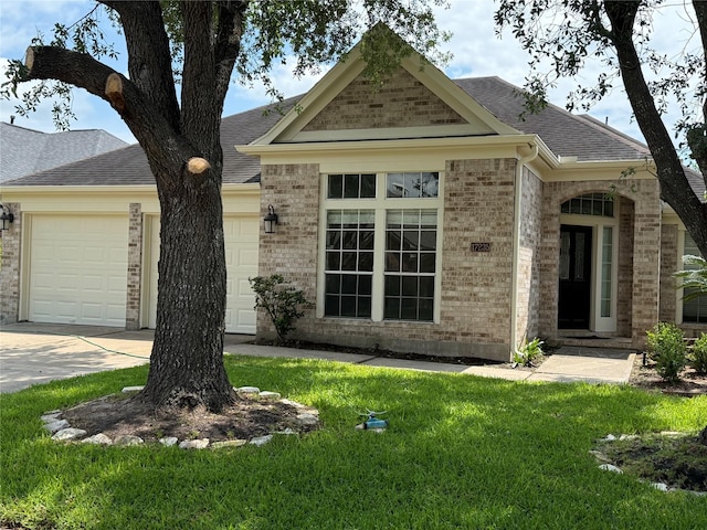17235 Eden Falls Ct, Houston, TX 77095 - view of front of house featuring a garage, brick siding, a shingled roof, a front yard, and concrete driveway
