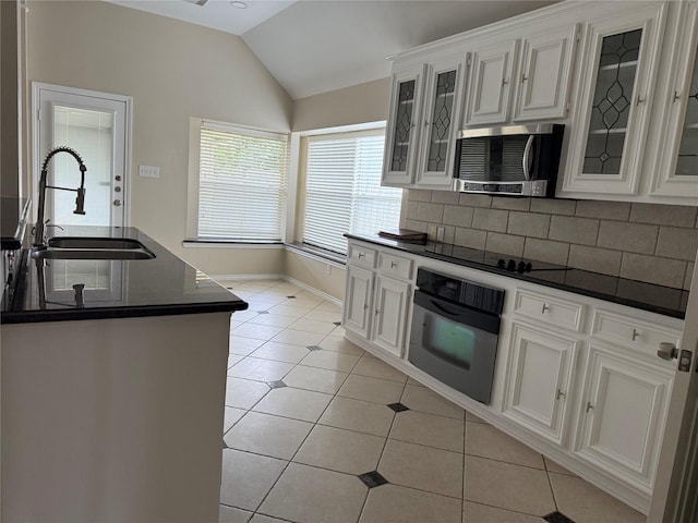 17235 Eden Falls Ct, Houston, TX 77095 - kitchen featuring black appliances, a sink, dark countertops, vaulted ceiling, and light tile patterned floors