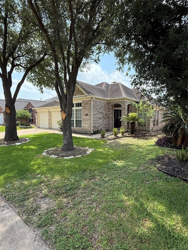 17235 Eden Falls Ct, Houston, TX 77095 - view of front of house with concrete driveway, a front lawn, a garage, and brick siding