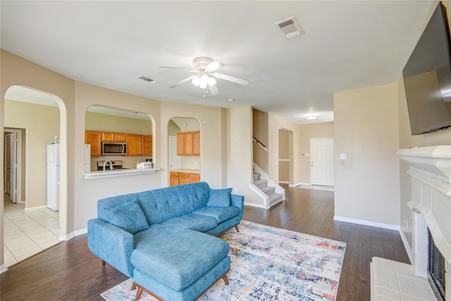 2810 Green Lodge Cir, Spring, TX 77373 - living room with dark wood-style flooring, ceiling fan, visible vents, and a tile fireplace
