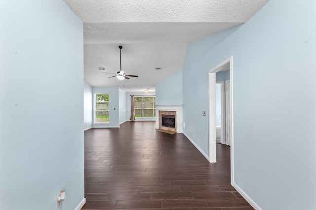unfurnished living room with baseboards, lofted ceiling, and dark wood-type flooring