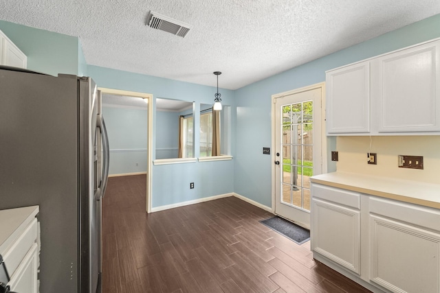 kitchen with visible vents, freestanding refrigerator, baseboards, and dark wood-type flooring