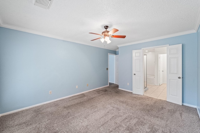 unfurnished bedroom featuring crown molding, carpet floors, a textured ceiling, baseboards, and visible vents