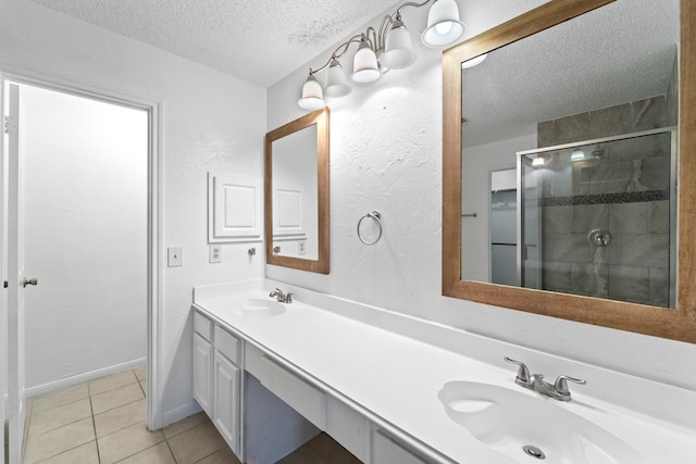 full bathroom with a sink, tile patterned floors, a stall shower, and a textured ceiling