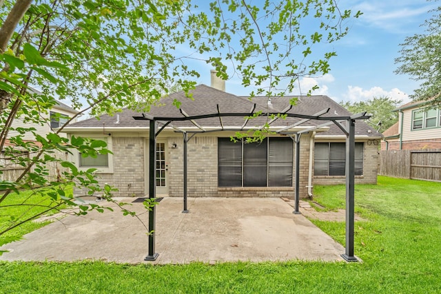 rear view of house featuring fence, a pergola, brick siding, a patio area, and a lawn