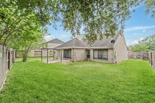 back of house with brick siding, a fenced backyard, a chimney, a patio, and a yard