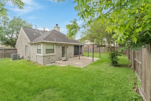 rear view of house featuring a chimney, roof with shingles, a fenced backyard, a yard, and a patio