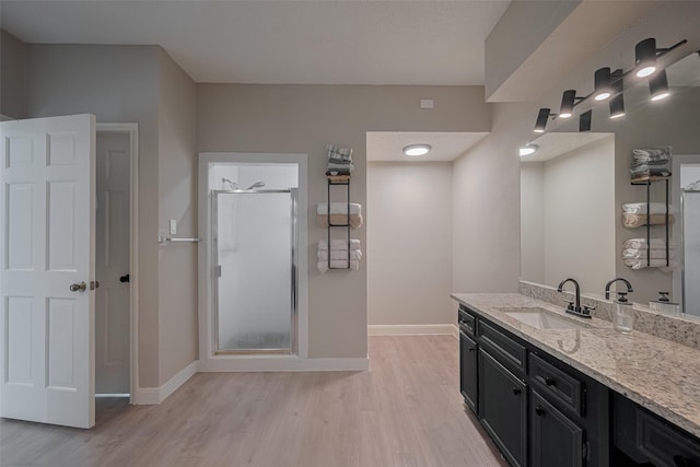 1709 Coles Farm Dr, Sugar Land, TX 77478 - bathroom featuring wood finished floors, a shower stall, vanity, and baseboards