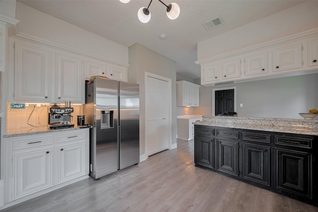 1709 Coles Farm Dr, Sugar Land, TX 77478 - kitchen with stainless steel refrigerator with ice dispenser, dark cabinets, white cabinets, and light wood-type flooring
