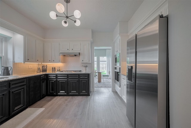 1709 Coles Farm Dr, Sugar Land, TX 77478 - kitchen with appliances with stainless steel finishes, dark cabinetry, white cabinetry, decorative backsplash, and light wood-style flooring
